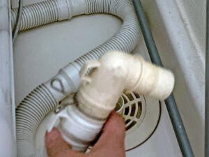 雑巾で排水パン内とホースを拭き掃除し、排水ホースをつなぐ